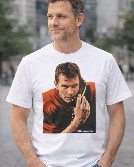 Man wearing a white t-shirt with a graphic of a man on a phone and '80s mindset' text, standing outdoors.