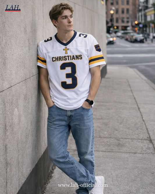Person wearing a white sports jersey with 'Christians' and number '3', leaning against a wall on a city street.